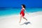 Beautiful free girl running on exotic beach with white sand and