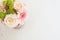 Beautiful fresh flowers on light marble table, top view. Pink roses and gerberas on a female work desk. Blogger lifestyle