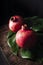 Beautiful fresh red pomegranates on a tropical leaf with a dark background.Appetizing ripe pomegranates and ready to eat.