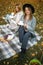 Beautiful friends spending time on a picnic blanket on the grass. Two young carefree smiling sisters making picnic eating fruits a