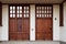 Beautiful front door of house made of dark wood against background of light wall