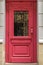 Beautiful front door in an old city. Elegant wooden door of red color.