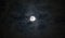 Beautiful full moon beneath wispy blue gray moody clouds, dramatic night sky