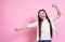 Beautiful funny emotional young girl in stylish glasses, in a white T-shirt with air bubbles on a pink background