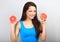 Beautiful funny grimacing brunette woman holding fresh red grapefruit near the face and looking humor. Closeup