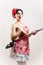 Beautiful funny housewife woman attractive pin-up girl playing vacuum cleaner as guitar on white