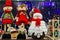 Beautiful funny white snowmen and dolls in red hats. Favorite Christmas and New Year s toys and decorations in the store. Festive