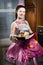 Beautiful funny young pinup woman in a dress and apron happy smiling and baking yummy cake portrait