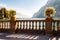 Beautiful Garda lake promenade with classic stone fence railings built on the edge with flowerpots with blooming white flowers.