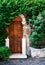 Beautiful garden with old antique door, flowers and ivy. Vintage