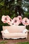 Beautiful garden vintage pink sofa in summer day. Interior wedding decor. Classic sofa decorated with large flowers in spring gard