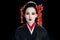 Beautiful geisha in black and red kimono and flowers in hair isolated on black