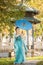 Beautiful geisha with a blue umbrella near green apple tree