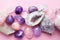 Beautiful gemstones,  geode amethyst and druses of natural purple mineral amethyst on a pink background. Amethysts and rose quartz