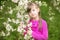 Beautiful gentle girl standing in a lush garden