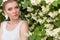 Beautiful gentle pretty girl bride in a white dress, with delicate make-up and hair, with earrings made from flowers and crys