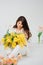 beautiful gentle woman brunette with a bouquet of yellow tulips and mimosa