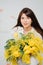 beautiful gentle woman brunette with a bouquet of yellow tulips and mimosa