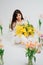 beautiful gentle woman brunette with a bouquet of yellow tulips and mimosa