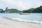 Beautiful gently waves on white sand beach. Soft sunlight. Traditional fishing boat and island background. Summer season. Mu