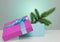 A beautiful gift box in blue, with a purple ribbon and bow. In it lies a branch of a Christmas tree. Beautiful Christmas