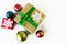 Beautiful gift box and Christmas decorations, balloons on white background. Preparation for New Year. Top view.