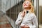 Beautiful ginger girl straightening tie on shirt in hall