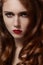 Beautiful ginger young woman with luxury hair style and fashion gloss makeup. Beauty closeup model with red hair