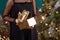 Beautiful gir opening cristmas gift box. lWoman`s  hands holding gold gift box. Christmas, new year, birthday concept. Festive