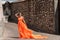 Beautiful girl in amazing fluttering orange dress.