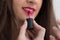Beautiful girl applying lipstick.