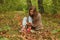 Beautiful girl in autumn forest. Holds in her hands yellow leaves