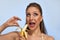 Beautiful girl with banana in studio, isolated. Food, fashion, healthcare, cosmetics concept, space for text