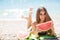 Beautiful girl on beach eating watermelon