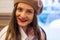 Beautiful girl in a beret sits near the window in a cafe