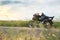 Beautiful girl biker lying on a motorcycle. She stopped on a road in a field.