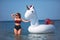 Beautiful girl in bikini swimming on giant unicorn during summer vacation