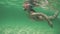 Beautiful girl in bikini swimming underwater, snorkeling in crystal clear, blue Caribbean sea water.