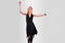 Beautiful girl in a black dress back dancing, on a gray background
