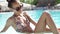 Beautiful girl in black sunglasses with amazing super slim fitnes body relaxing at pool and enjoing warm summer day