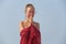 Beautiful girl with blond hair, in a red dress on the background of the sea. Summer girl on the sea. Tenderness, alone with nature