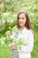 Beautiful girl blowing. portrait of a girl in a blooming apple tree.