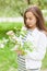 Beautiful girl blowing. portrait of a girl in a blooming apple tree.