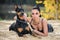 Beautiful girl with blue eyes posing with a doberman lying on the sand