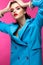 Beautiful girl in blue suit on pink background with creative make-up and fashionable style. Beauty face.