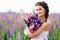 Beautiful girl with bouquet of lupine flowers in hands