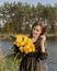 Beautiful girl with a bouquet of yellow roses. Effective woman near the river. Pretty Woman. Teen girl with yellow