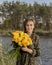 Beautiful girl with a bouquet of yellow roses. Effective woman near the river. Pretty Woman. Teen girl with yellow