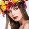 Beautiful girl with bright autumn wreath of