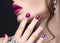 Beautiful girl with a bright evening make-up and pink manicure with rhinestones. Nail design. Beauty face.